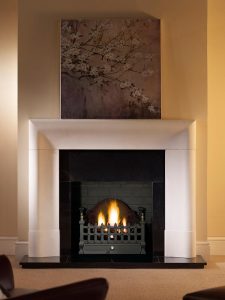Delection 56" Agean limestone mantel with Castle fire basket in black, decorative gas fire with ceramic coal, granite slips, black painted reeded fireboard chamber, 60" slabbed granite hearth and slabbed granite back hearth